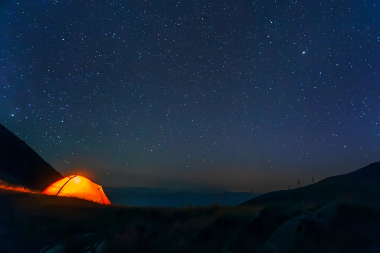 a camp site under a night sky filled with stars