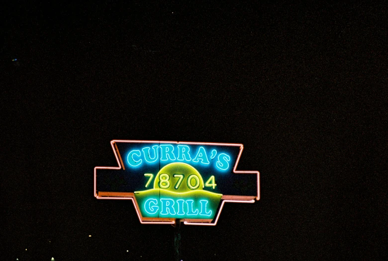 a sign advertising the burrito burger restaurant on a city street at night