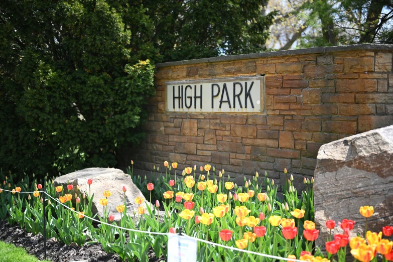 a sign and flowers in front of a brick building