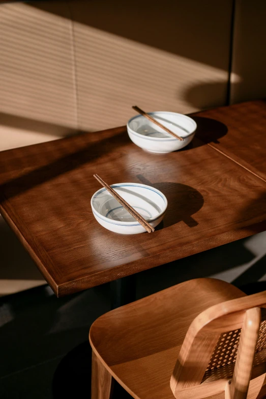 two plates on a table top with chopsticks on the side