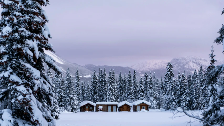 a snowy mountain scene with some cabins