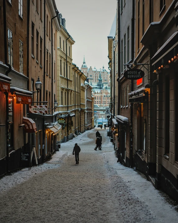 pedestrians are walking down a snow covered street