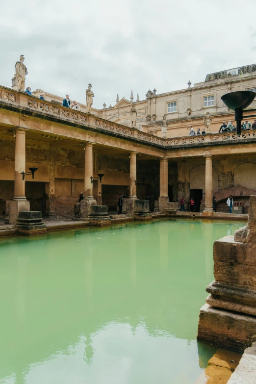 a long pool of water with a statue near by