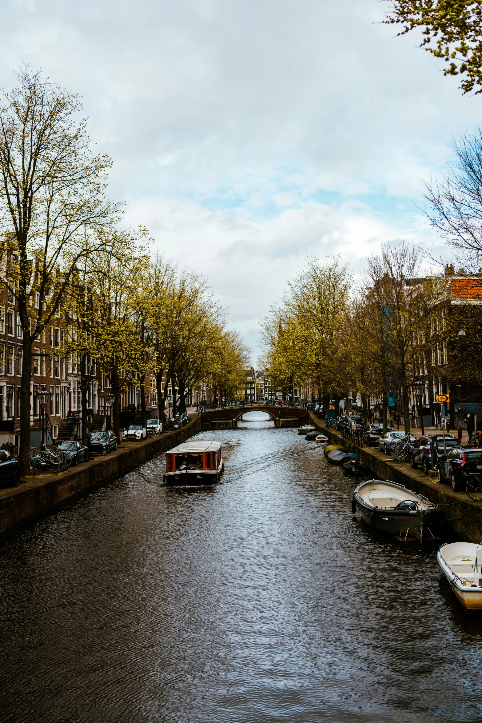 some boats parked along a narrow channel near buildings