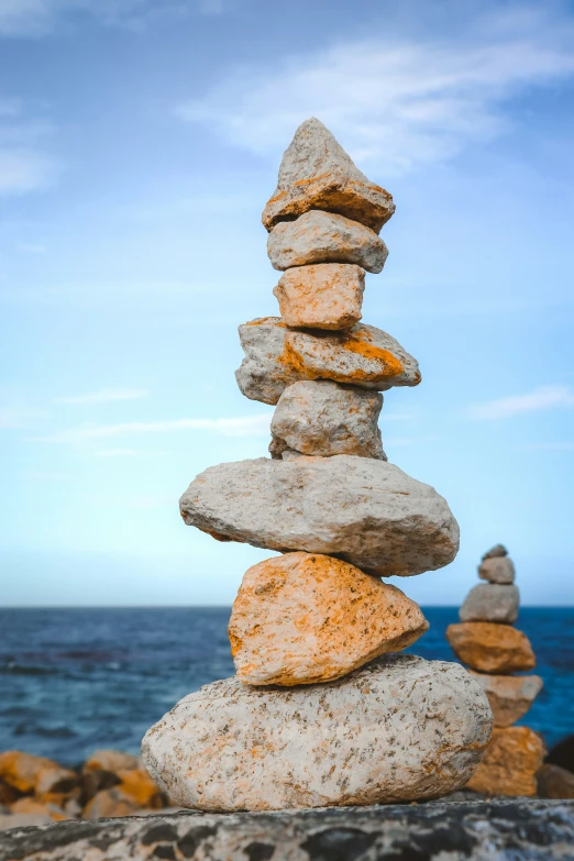 large pile of rocks standing in the middle of the ocean