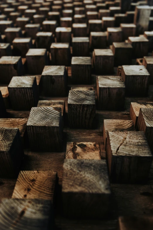 square wooden planks are arranged in rows and stacked high