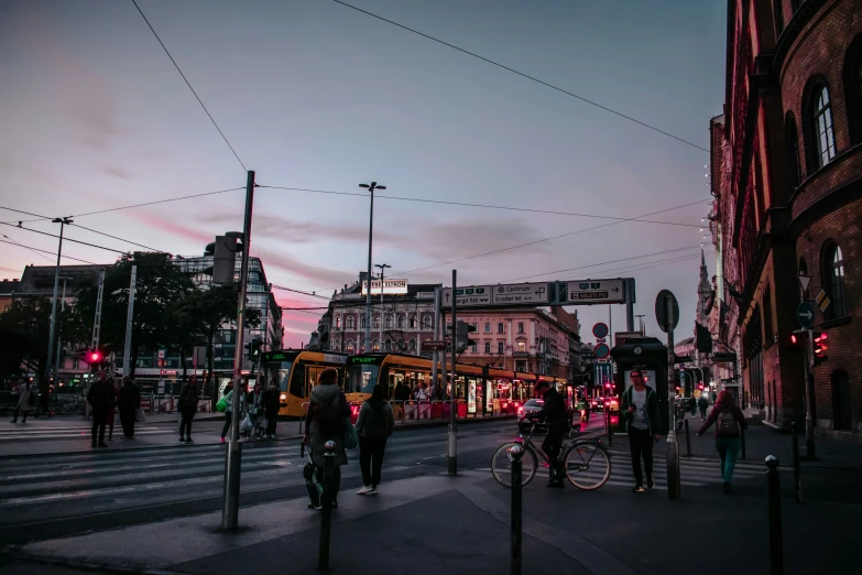 many people walking on a crowded street at dusk