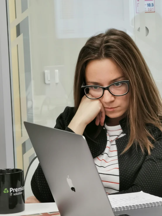 a young lady sitting at a desk on her laptop