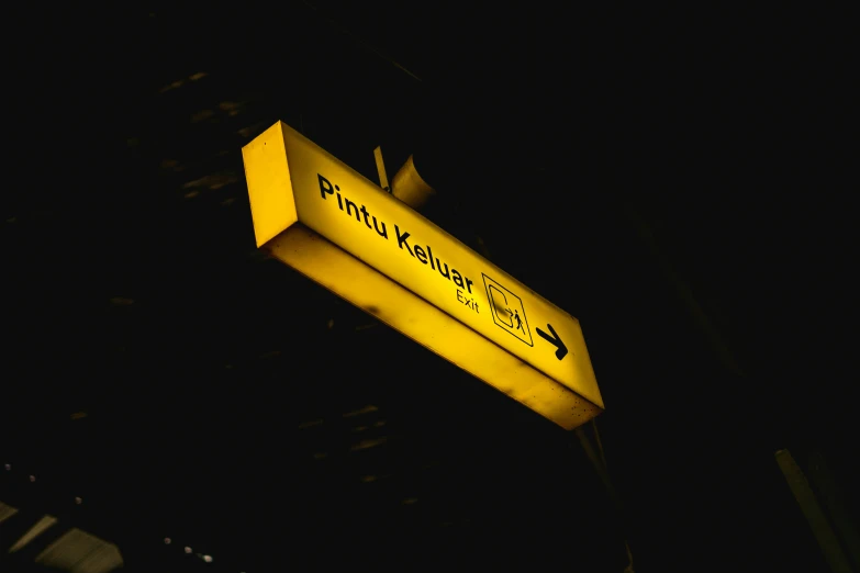 a street sign at night with one light on