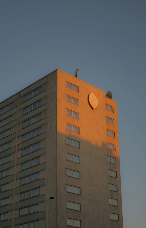 a building with a sunlit tower and two smaller round windows