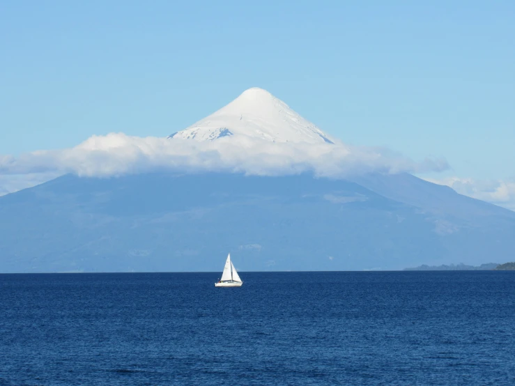 boat out on the open water with snow covered mountain in the background