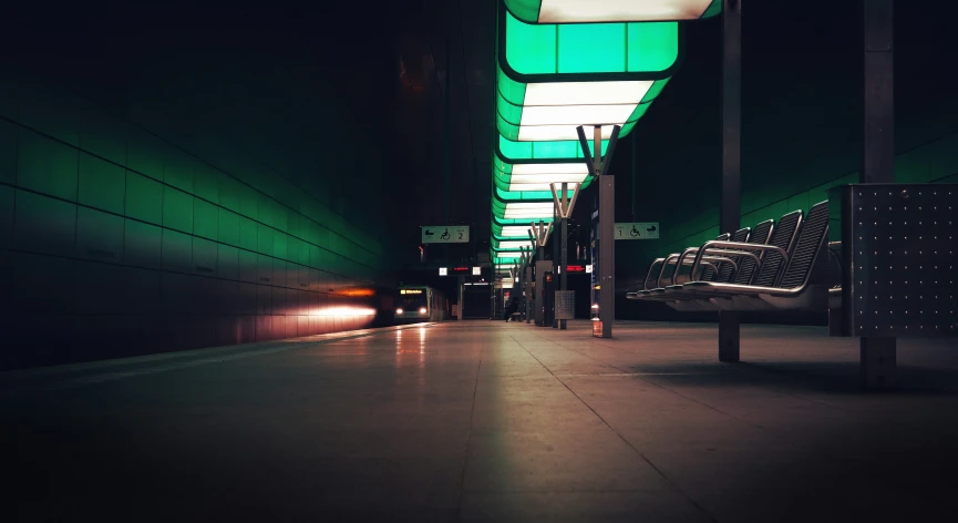 the subway has dark green lights and the tracks are long