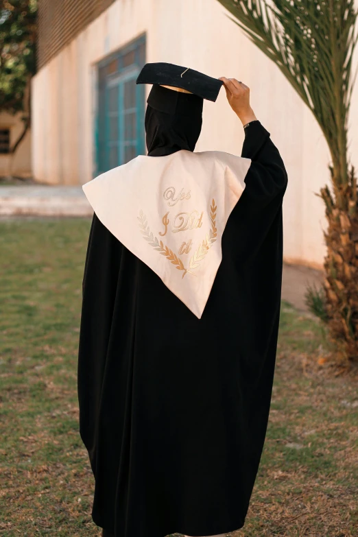 a graduate putting his cap and gown on