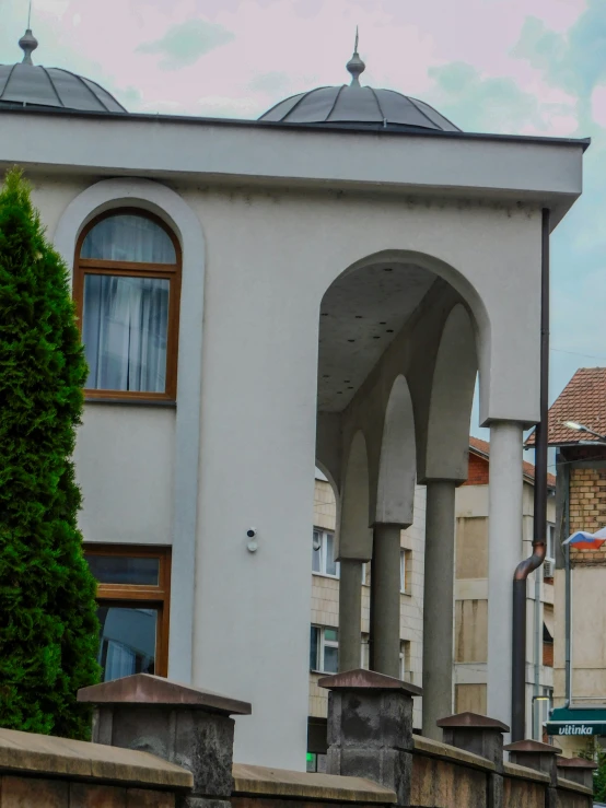 a tall clock on the side of a white building