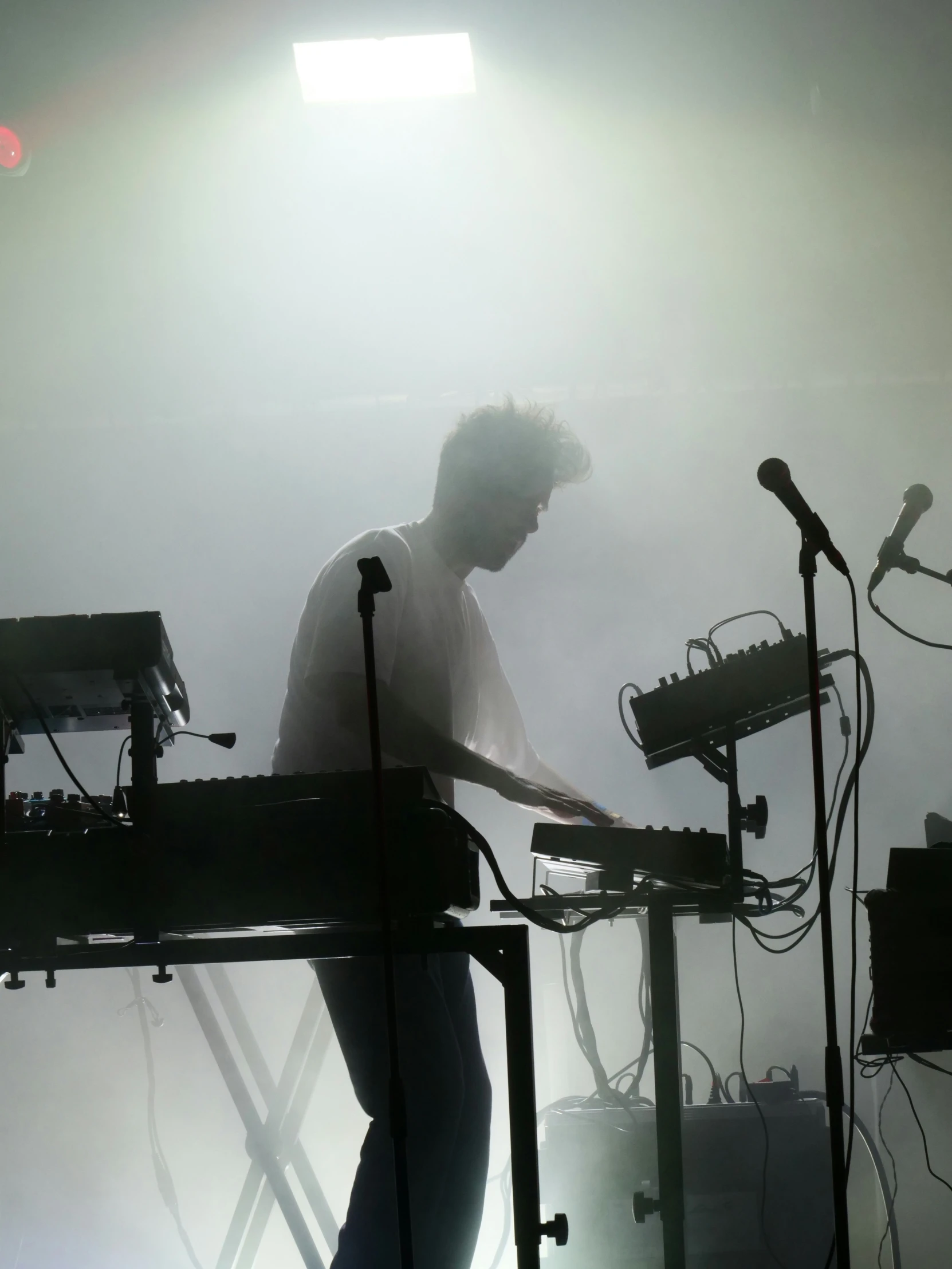 a man standing behind a keyboard on a stage