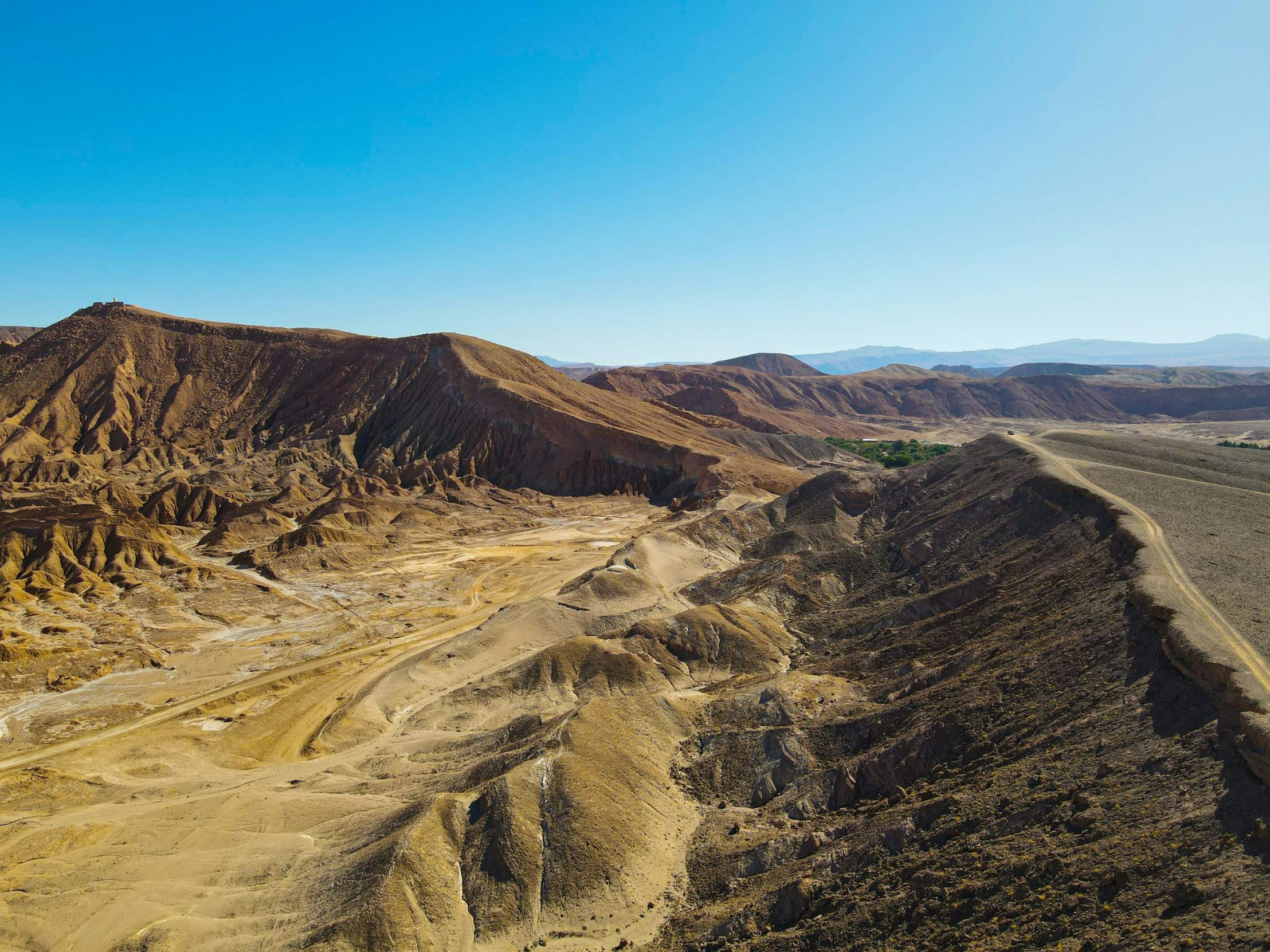 an aerial view of desert land with mountains