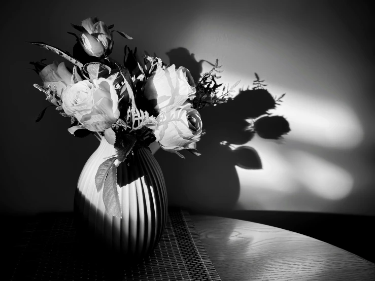 a black and white pograph of flowers in a vase