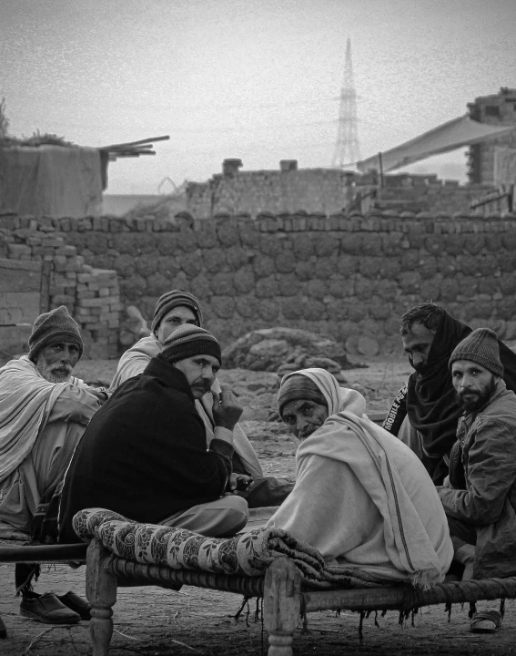 a group of people sitting on a bench in the middle of an open field