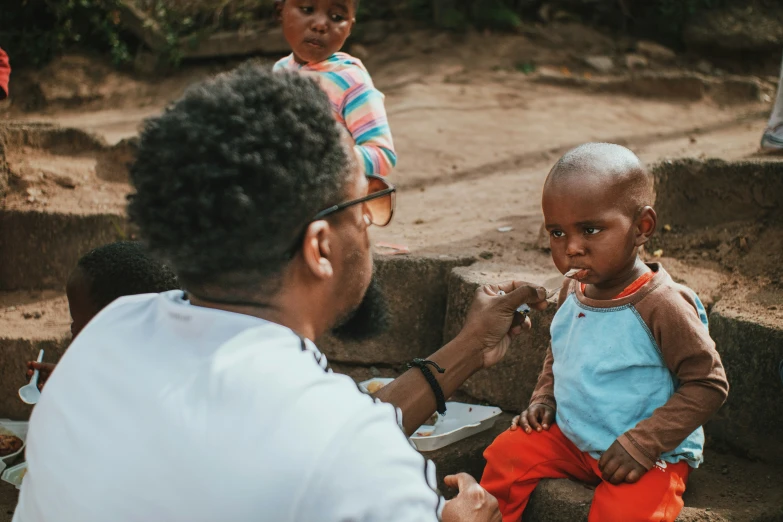 a woman is handing a baby a spoon