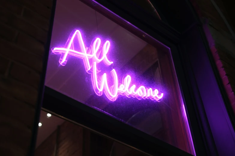 the neon sign is behind a window in front of the store