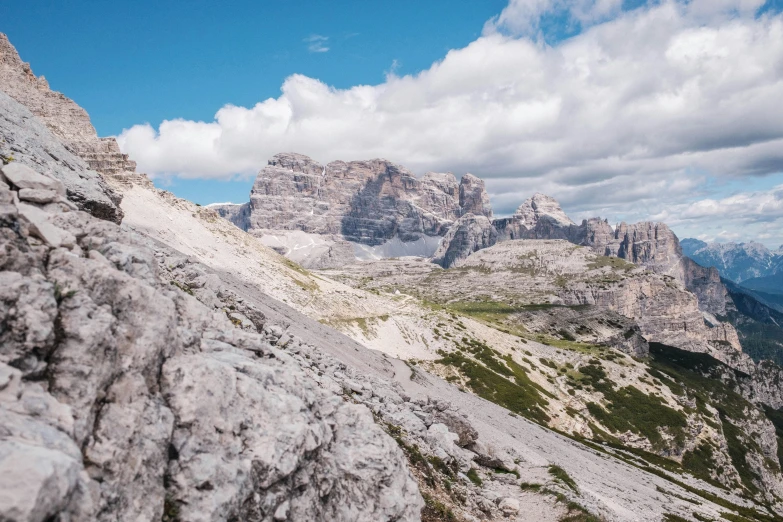 two large rocky mountains under clouds and blue sky