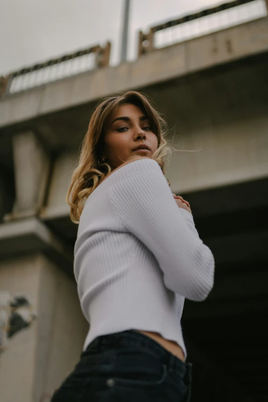 a beautiful young lady wearing jeans and a top