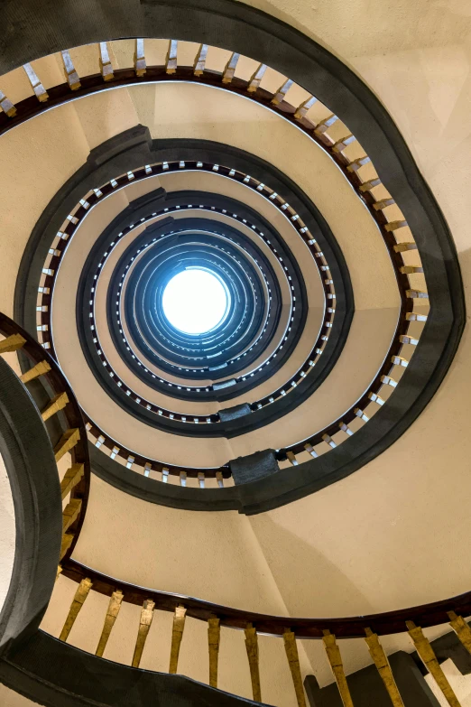 a spiral staircase in the building with light streaming through