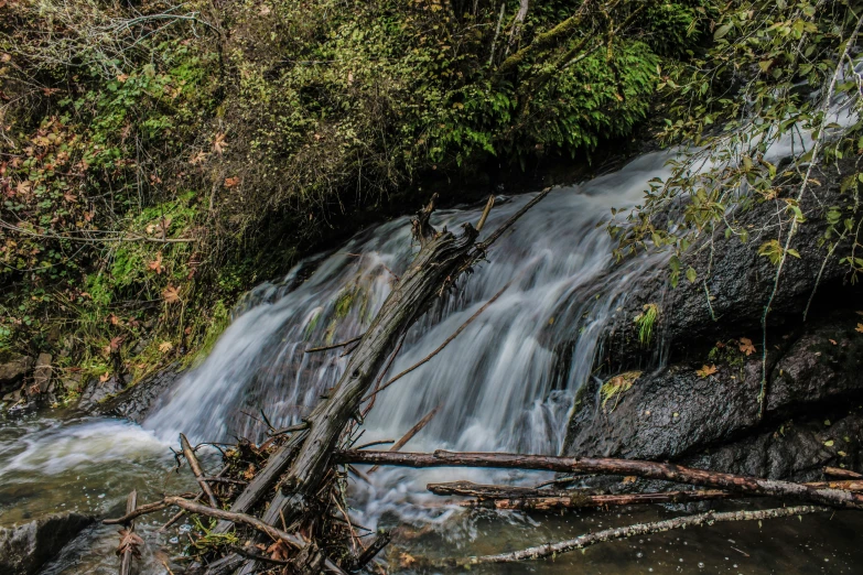 water gushing over large rocks, causing small waves