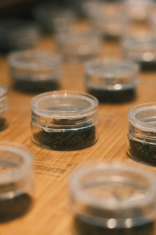 small glass jars of spices are placed on a wooden surface