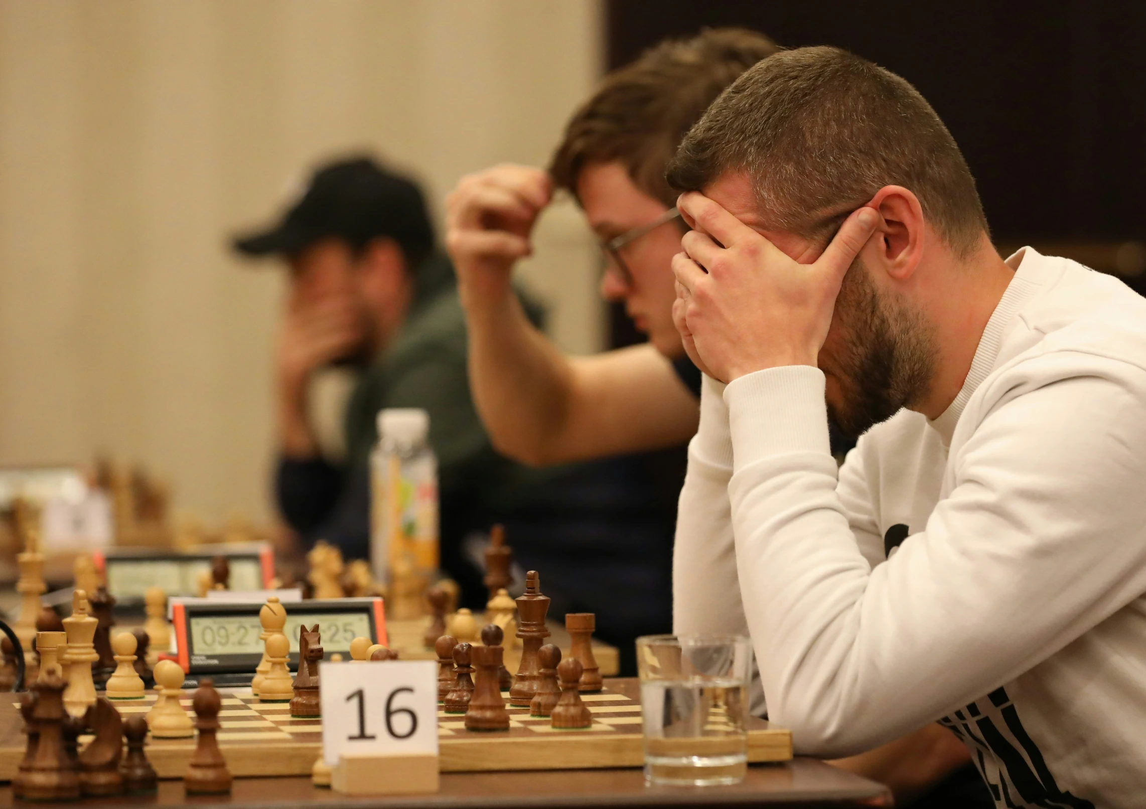 two men sitting at a table with a chess board