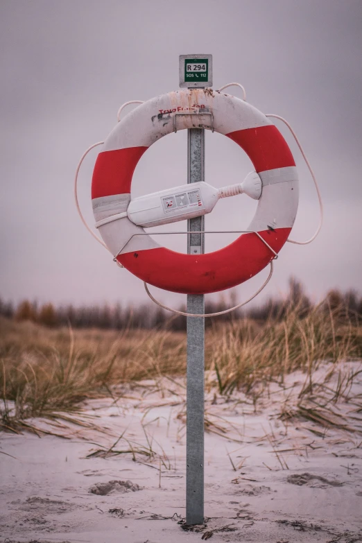 a life preserver stand at the edge of the sand