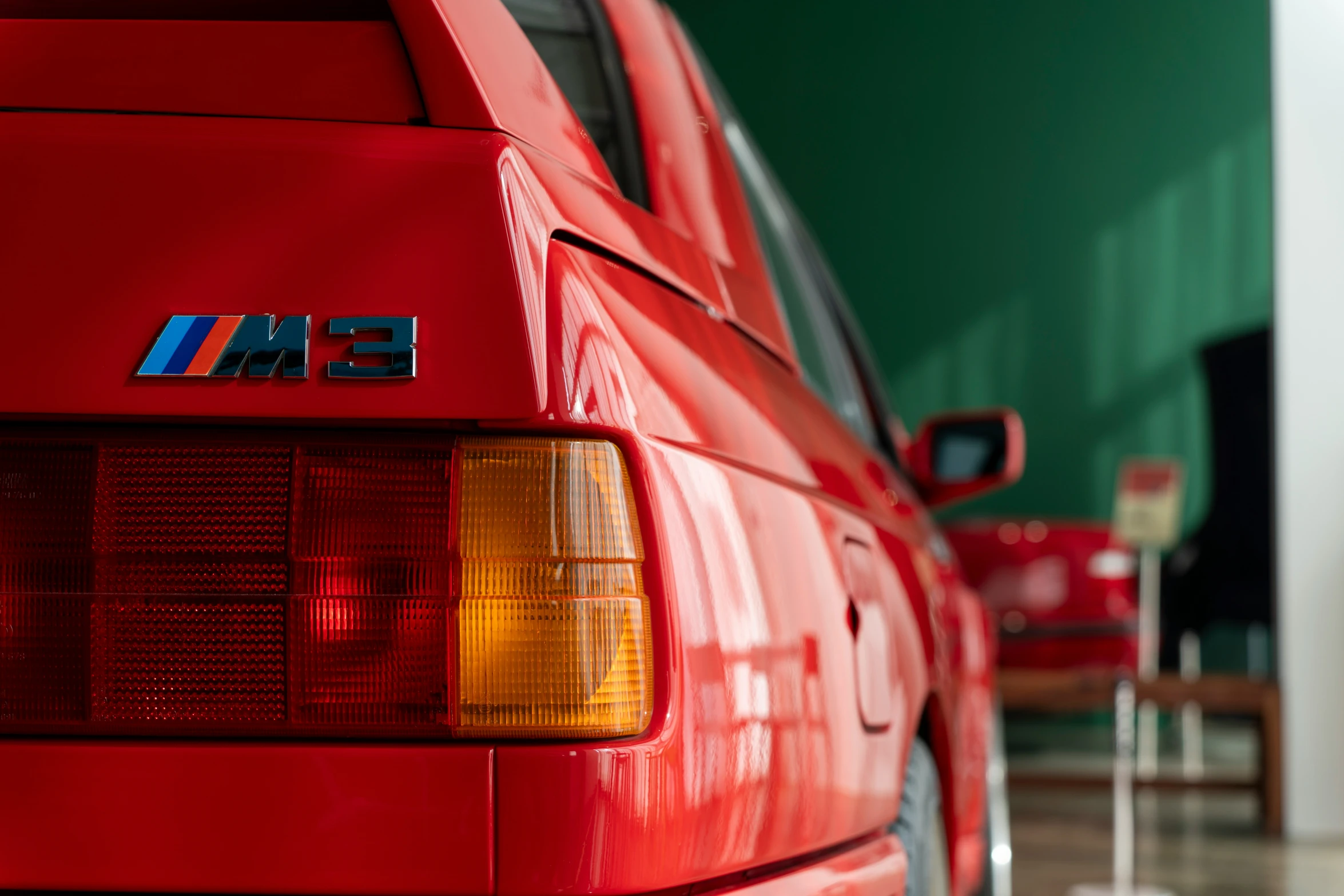 the tail lights of a red car parked in a garage