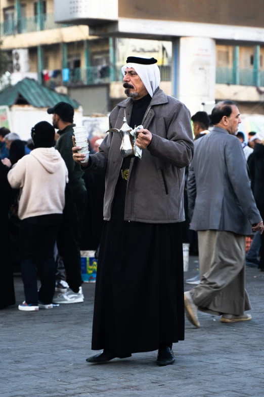 man in grey jacket and black dress drinking soing