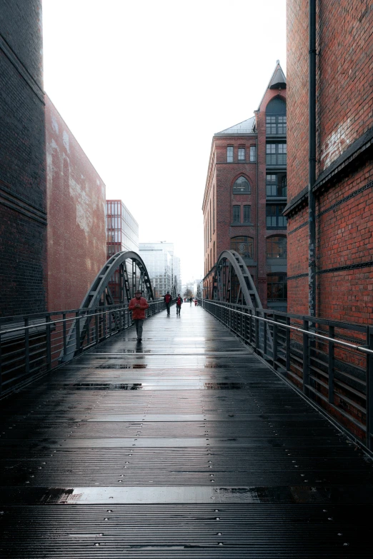 a person walks across a brick walkway on a rainy day