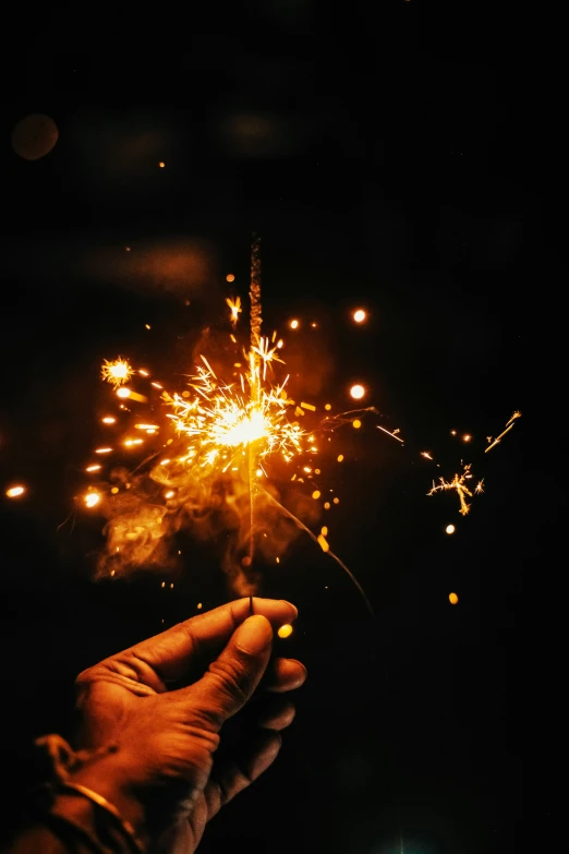 a hand holding a sparkler that has fire