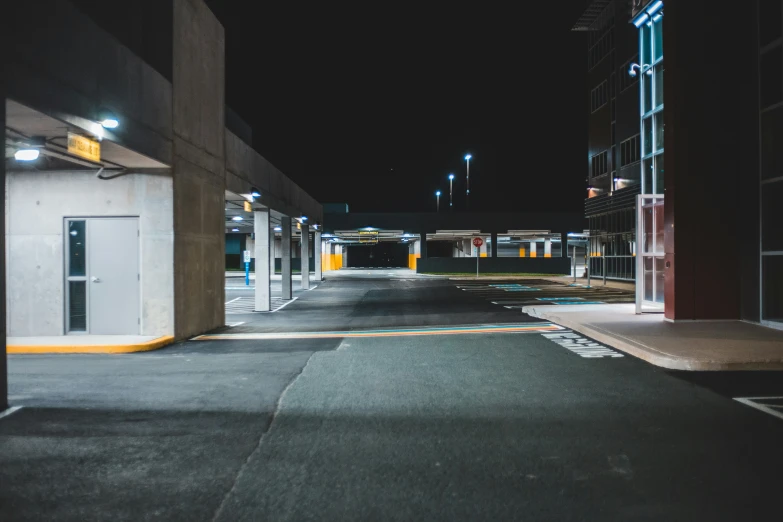 a deserted street at night in front of a large building