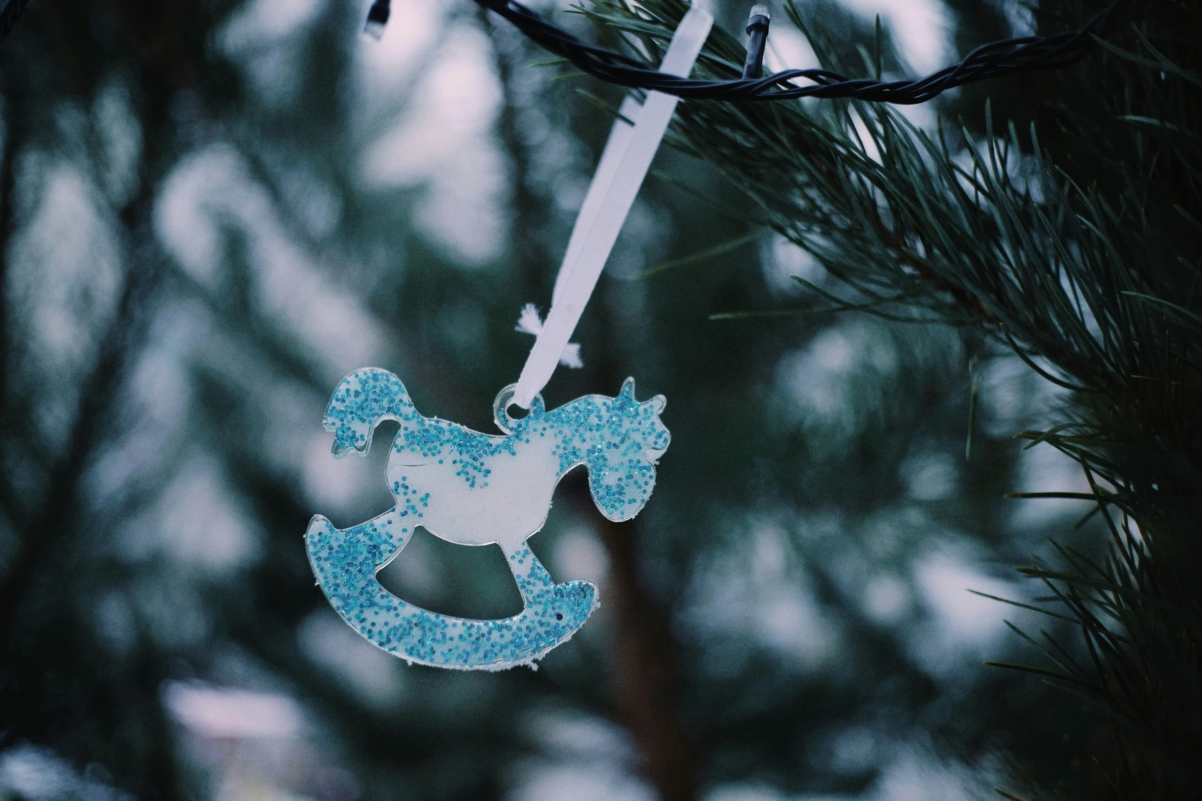 an ornament hanging from a tree, with trees in the background