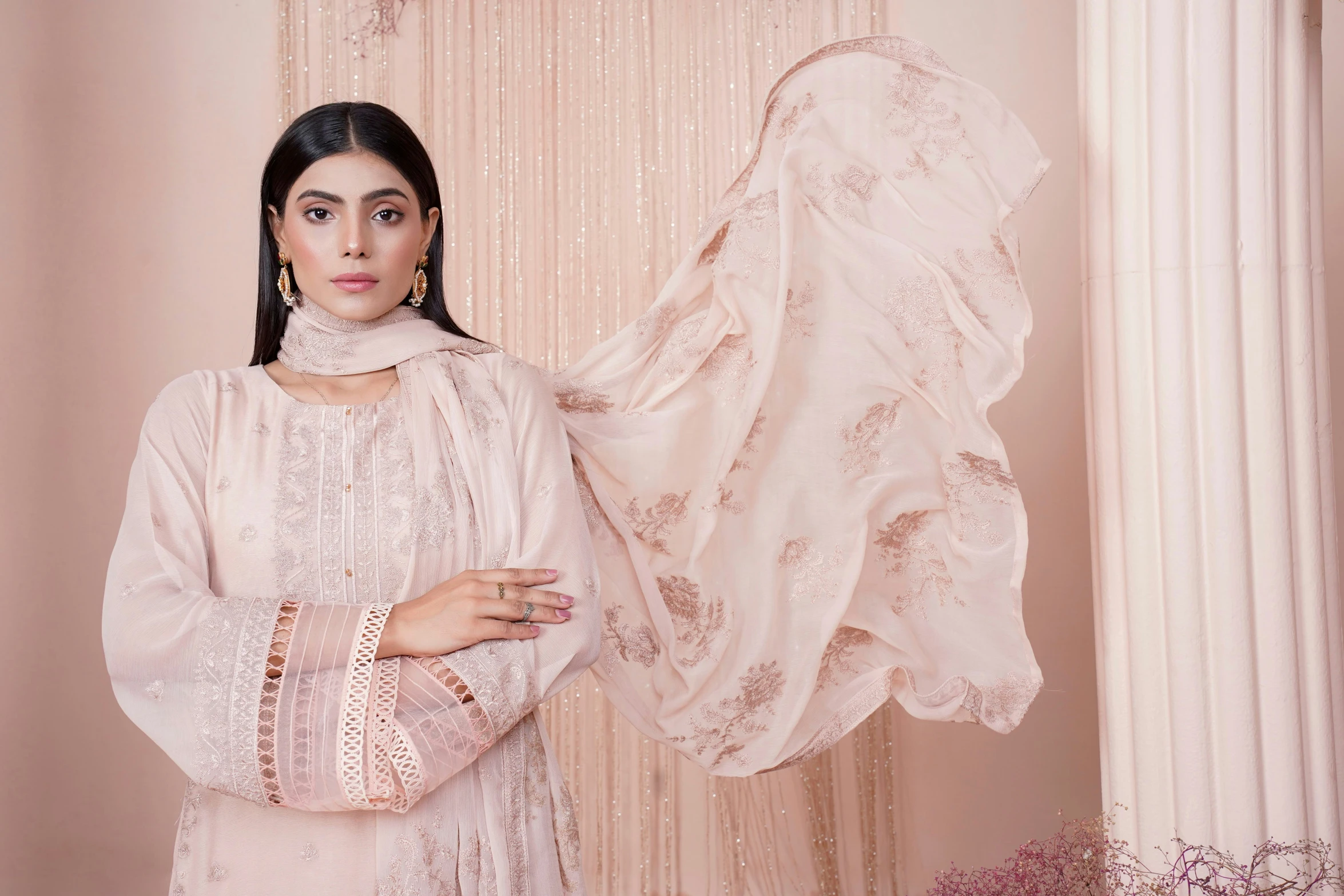 woman holding her bridal attire next to the curtain