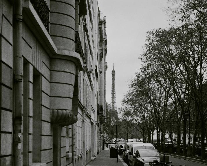 cars lined up on a street near tall buildings