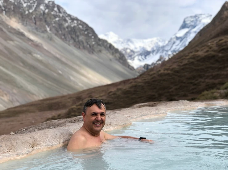 the man is relaxing in the  spring in mountains