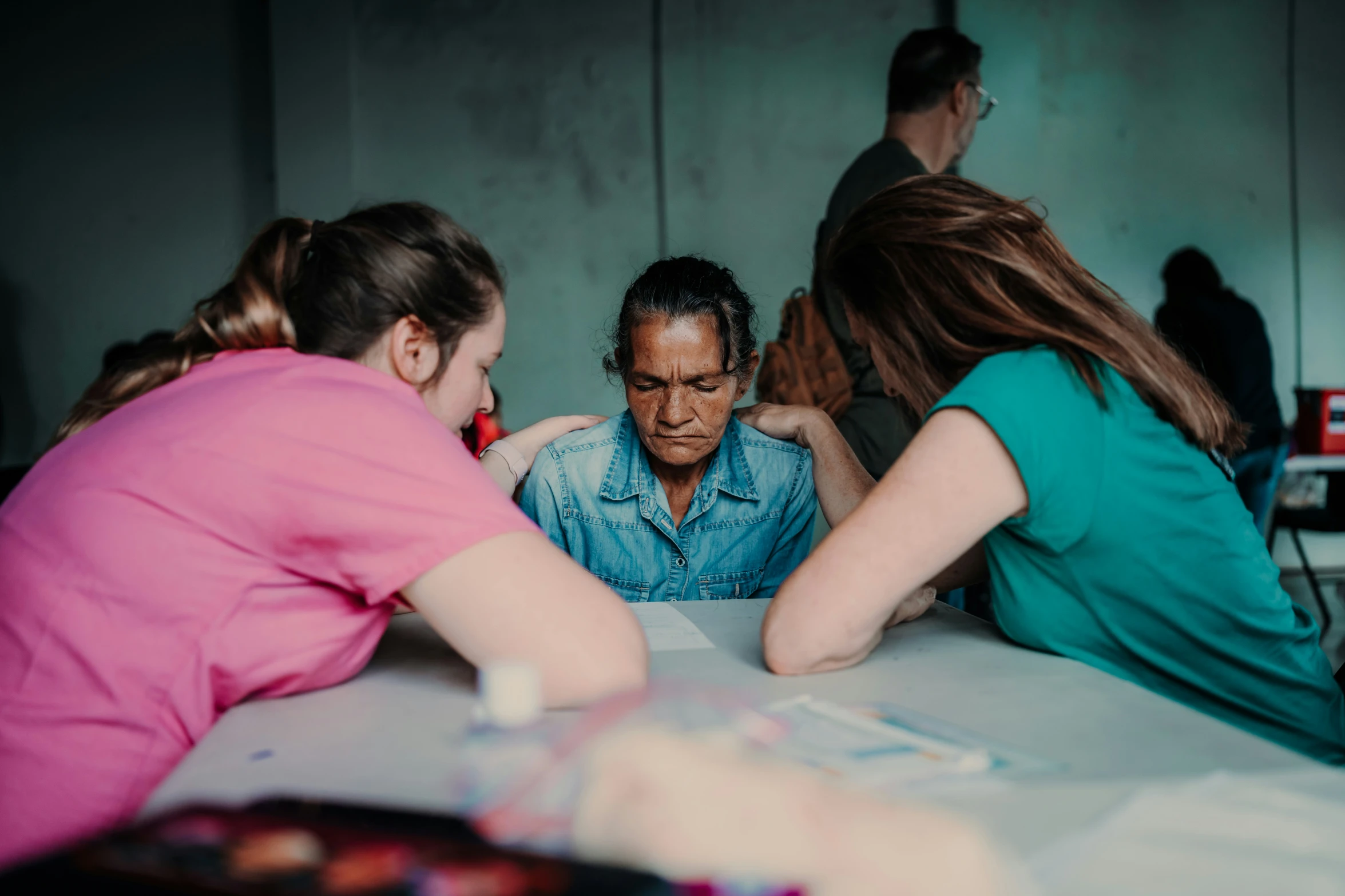 people sitting at table with one person writing