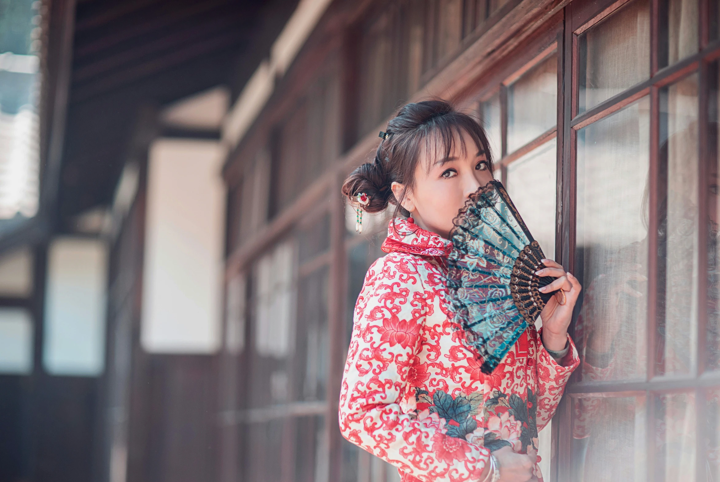 a girl in kimono is holding a fan