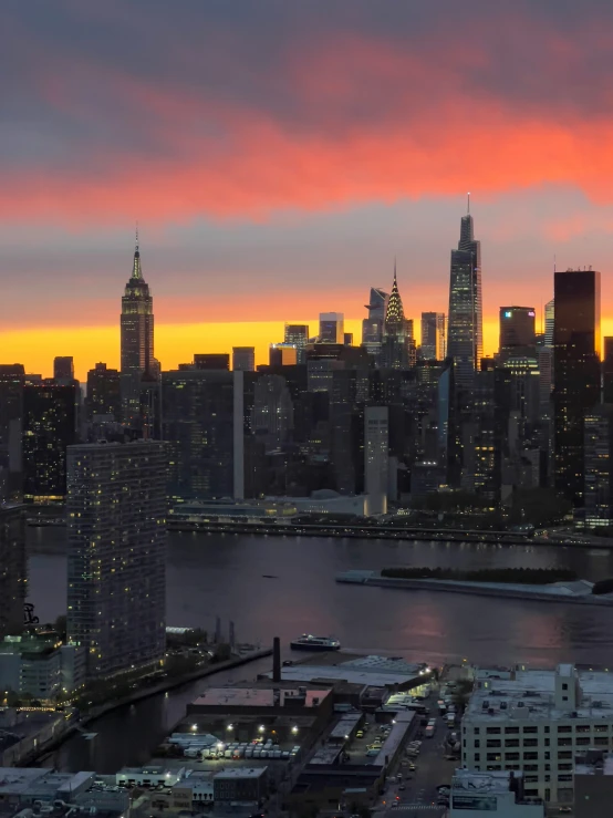 the sun sets over a large city in new york