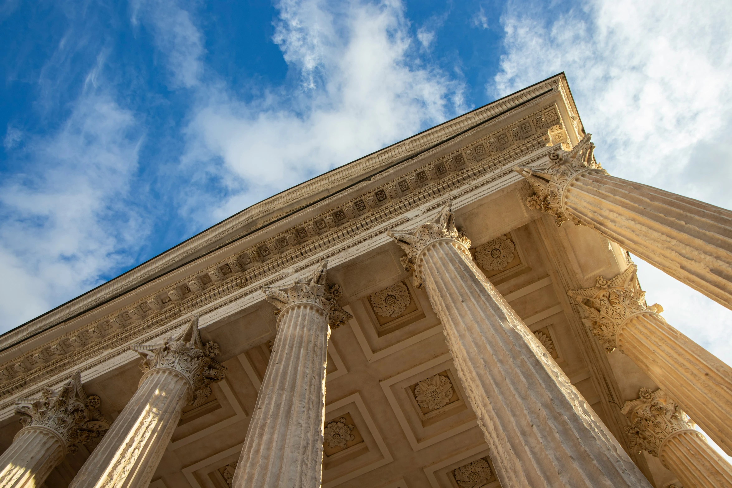 a stone building with columns is under the blue sky