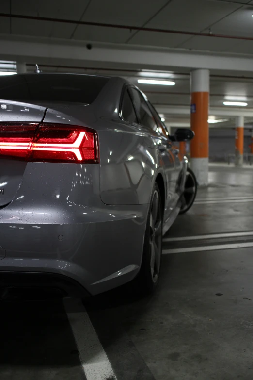 a white car with a black taillight in a parking garage