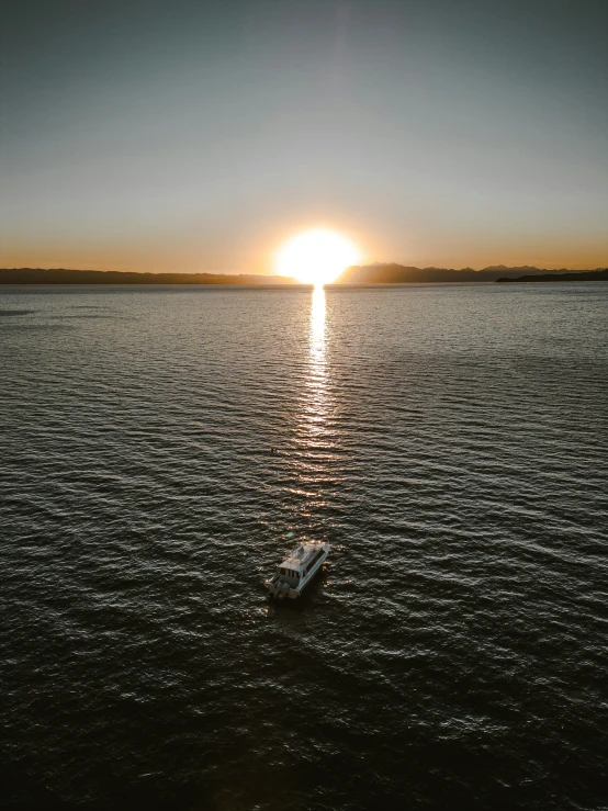 a row boat is floating on the water at sunset