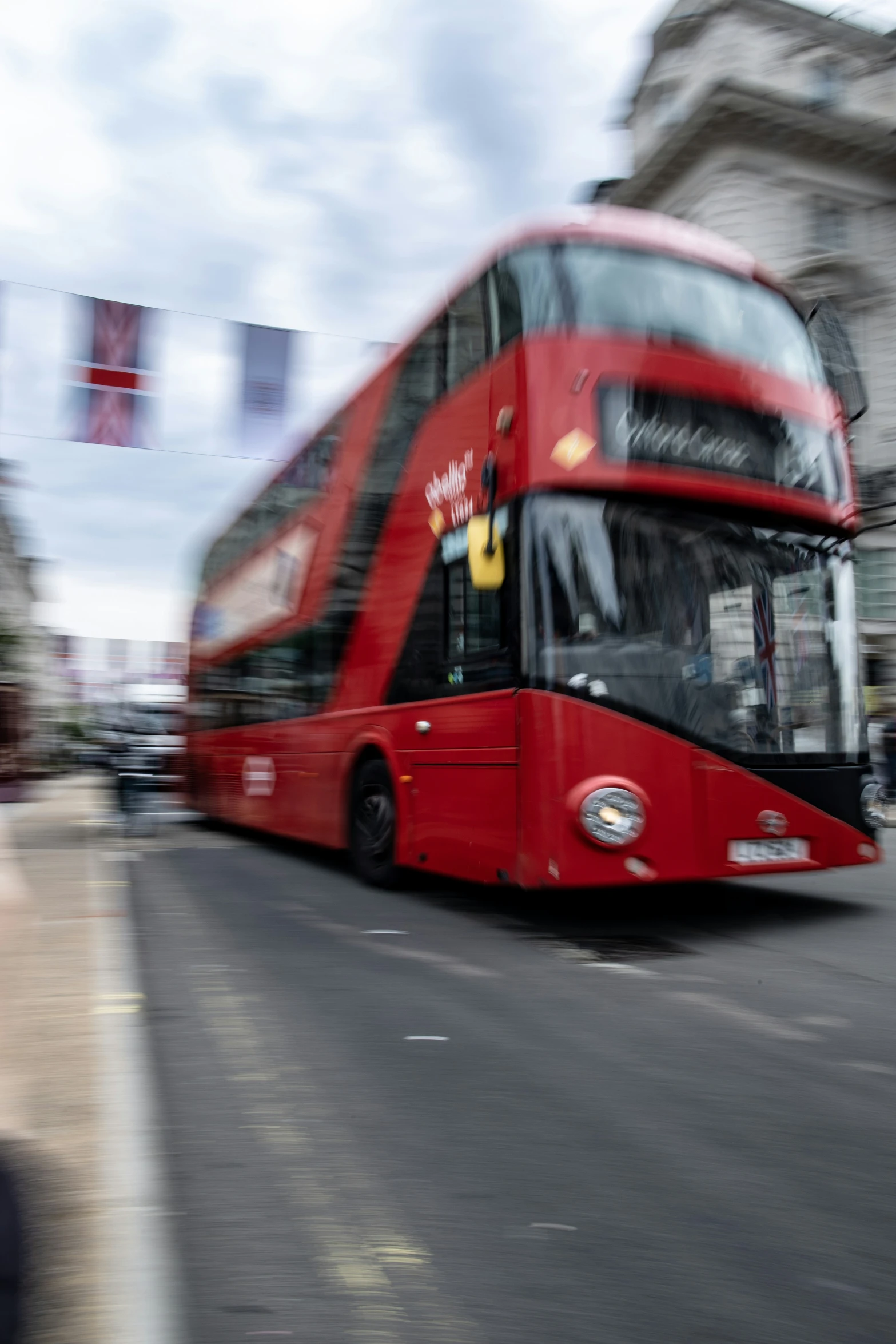 a red bus travels down the street in a blurry po