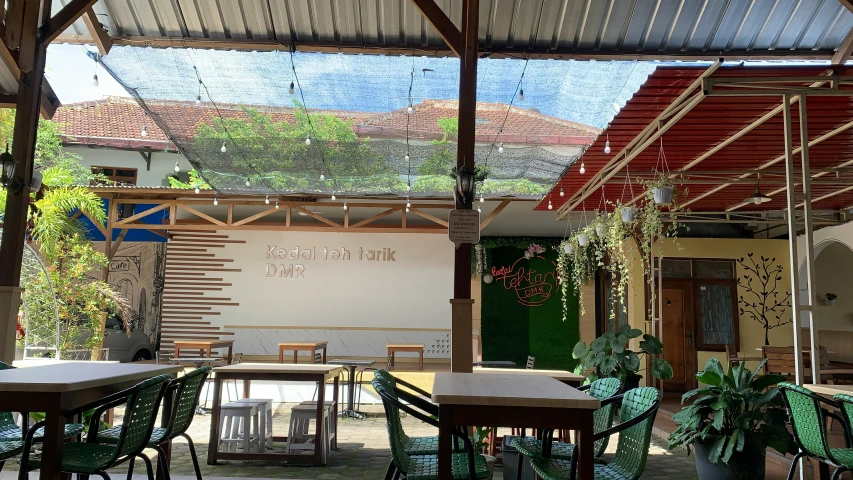 a covered patio with tables and chairs and lots of plants