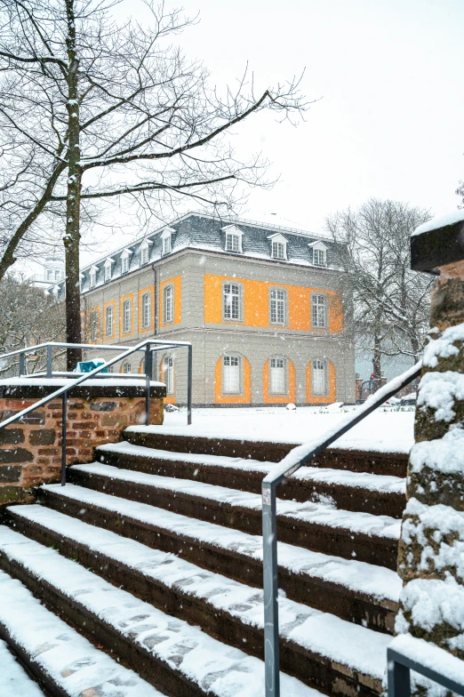 a snow covered stone stair railing and some snow covered stairs