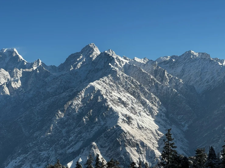 the mountains have snow covered tops as the moon rises